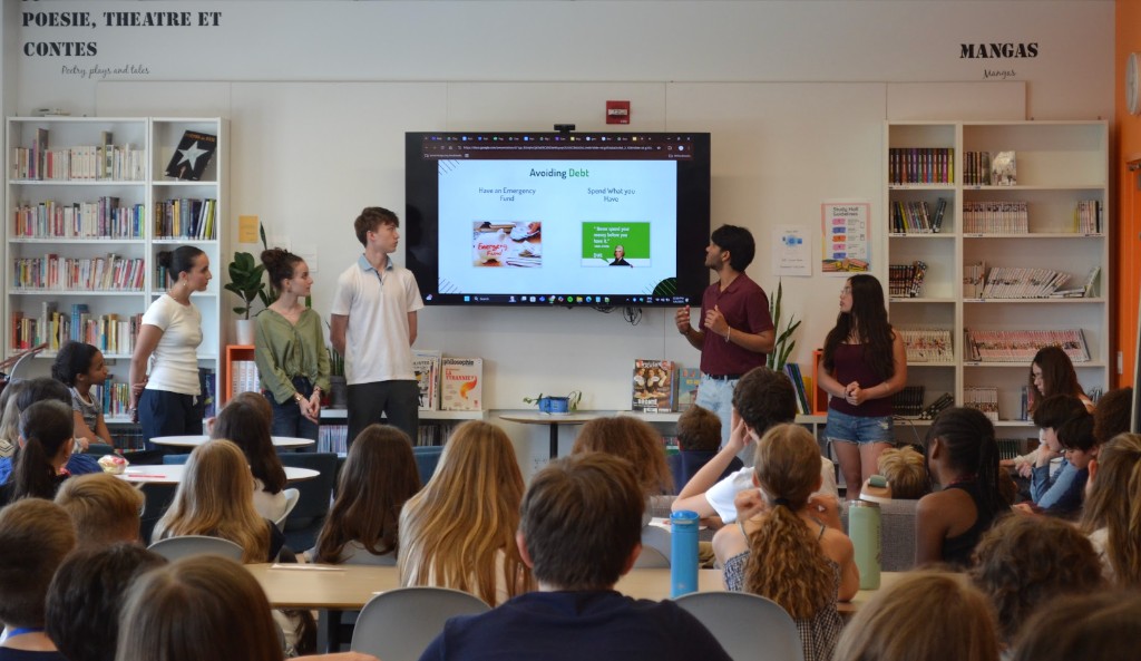 Student mentors presenting a financial literacy lesson to a classroom of peers