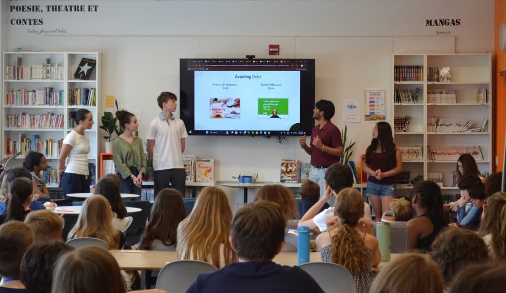 Student mentors presenting a financial literacy lesson to a classroom of peers
